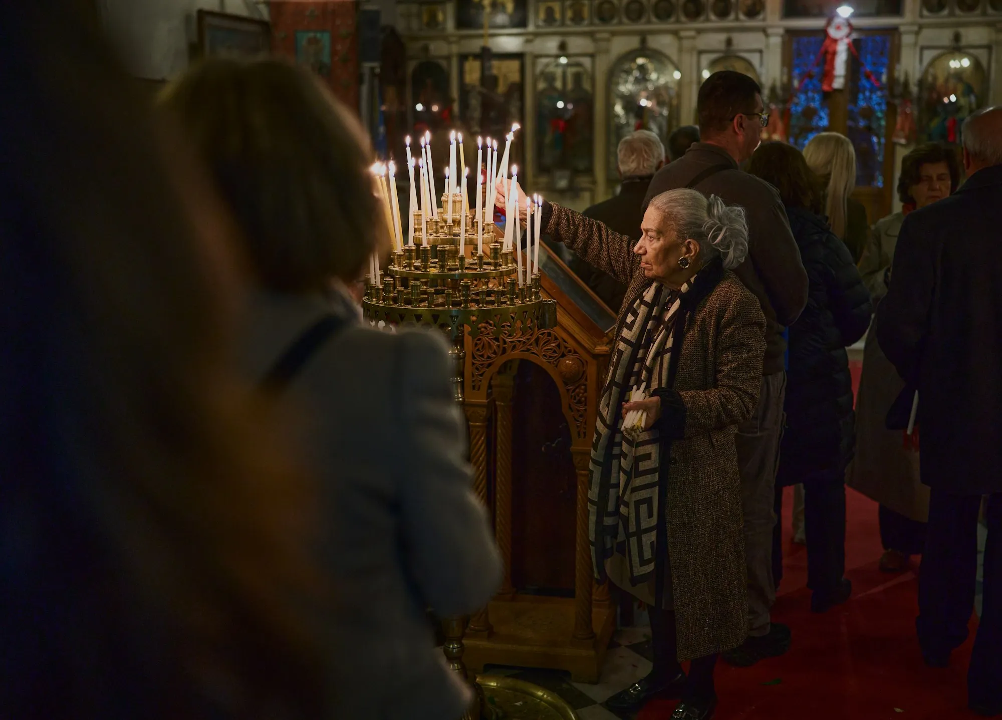 Peregrina acendendo velas no interior de uma igreja ortodoxa