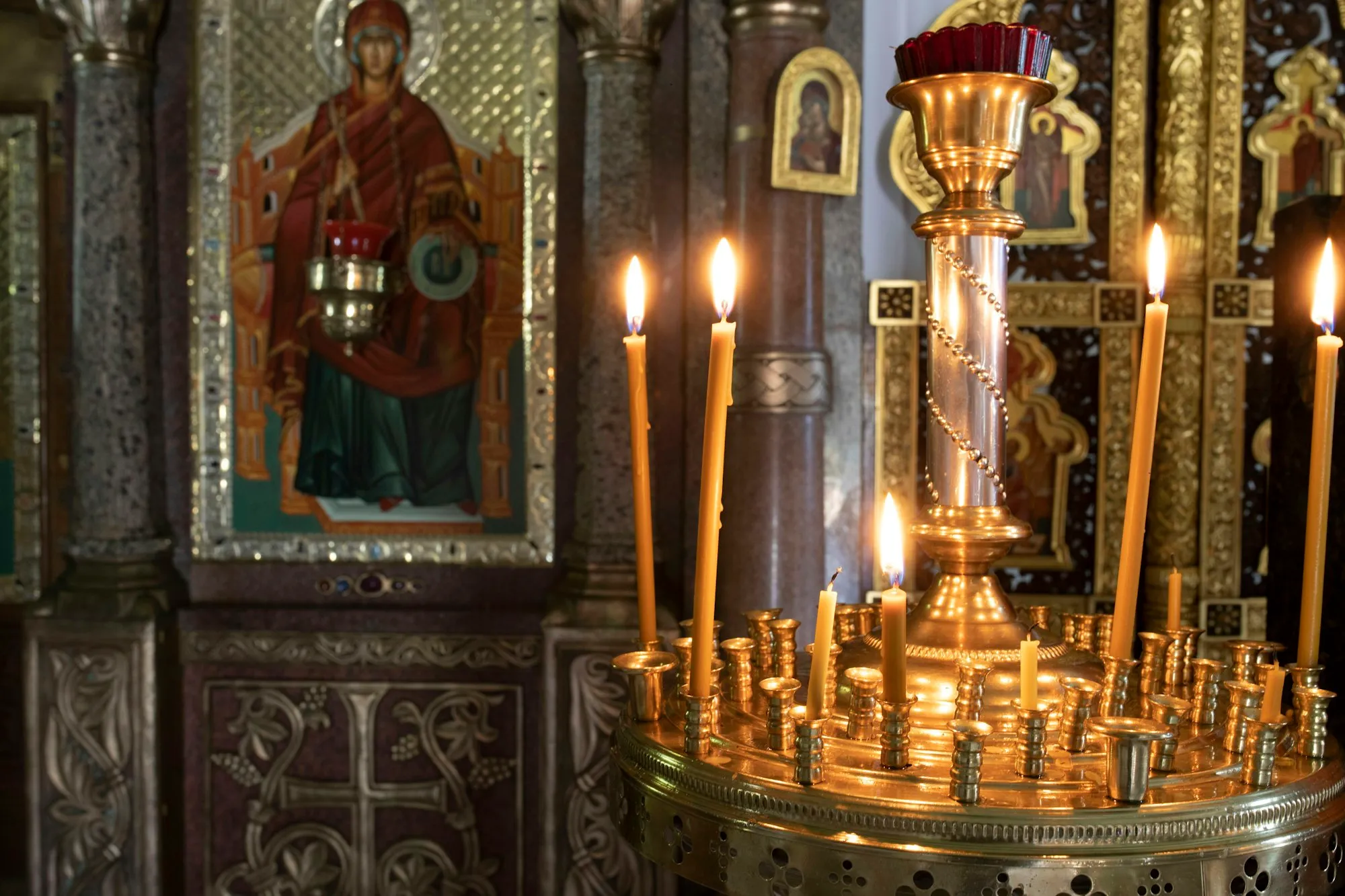Velas acesas em castiçal dourado de igreja ortodoxa