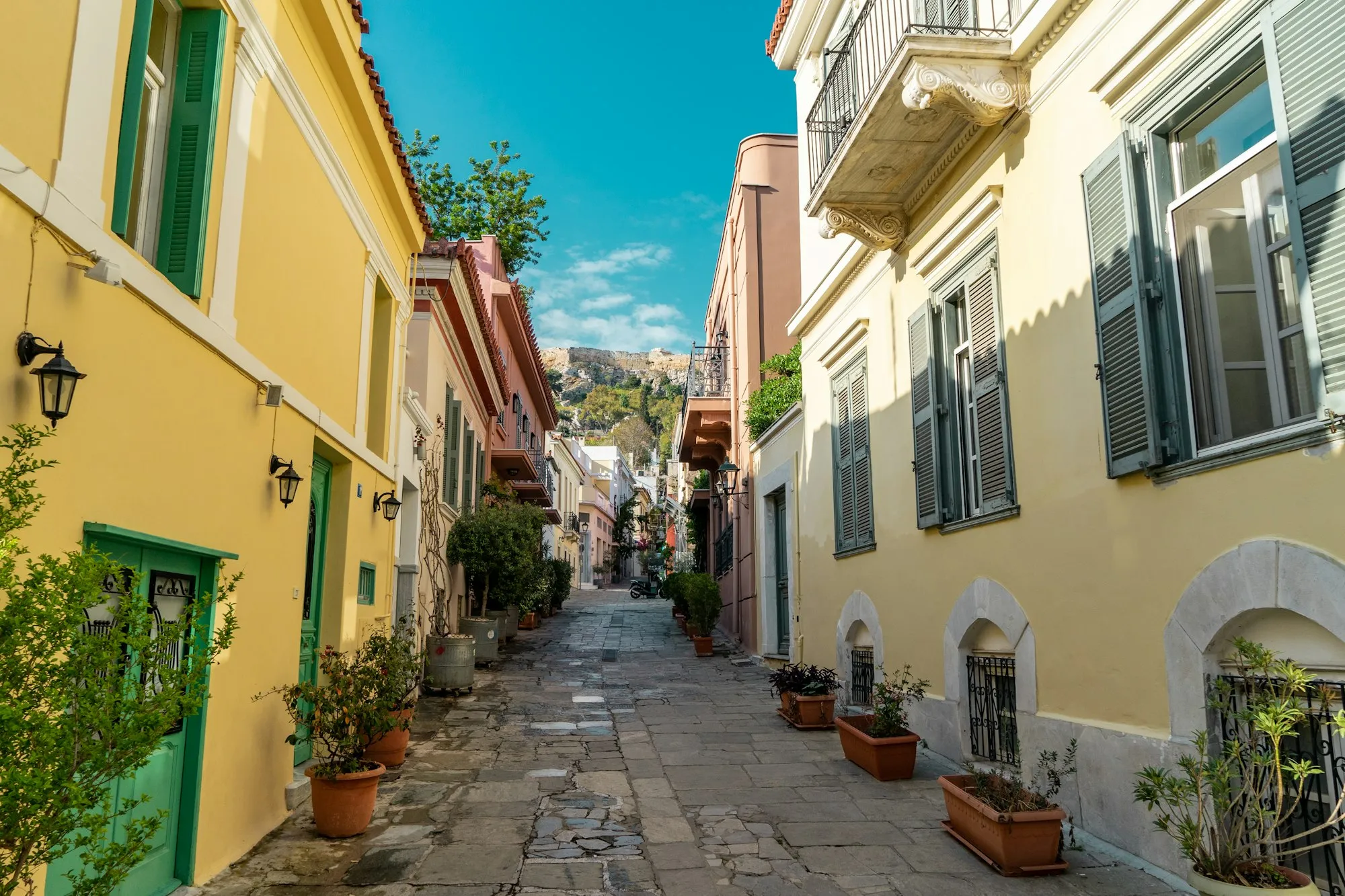 Ruela de pedra com vasos de plantas no bairro de Plaka, Atenas